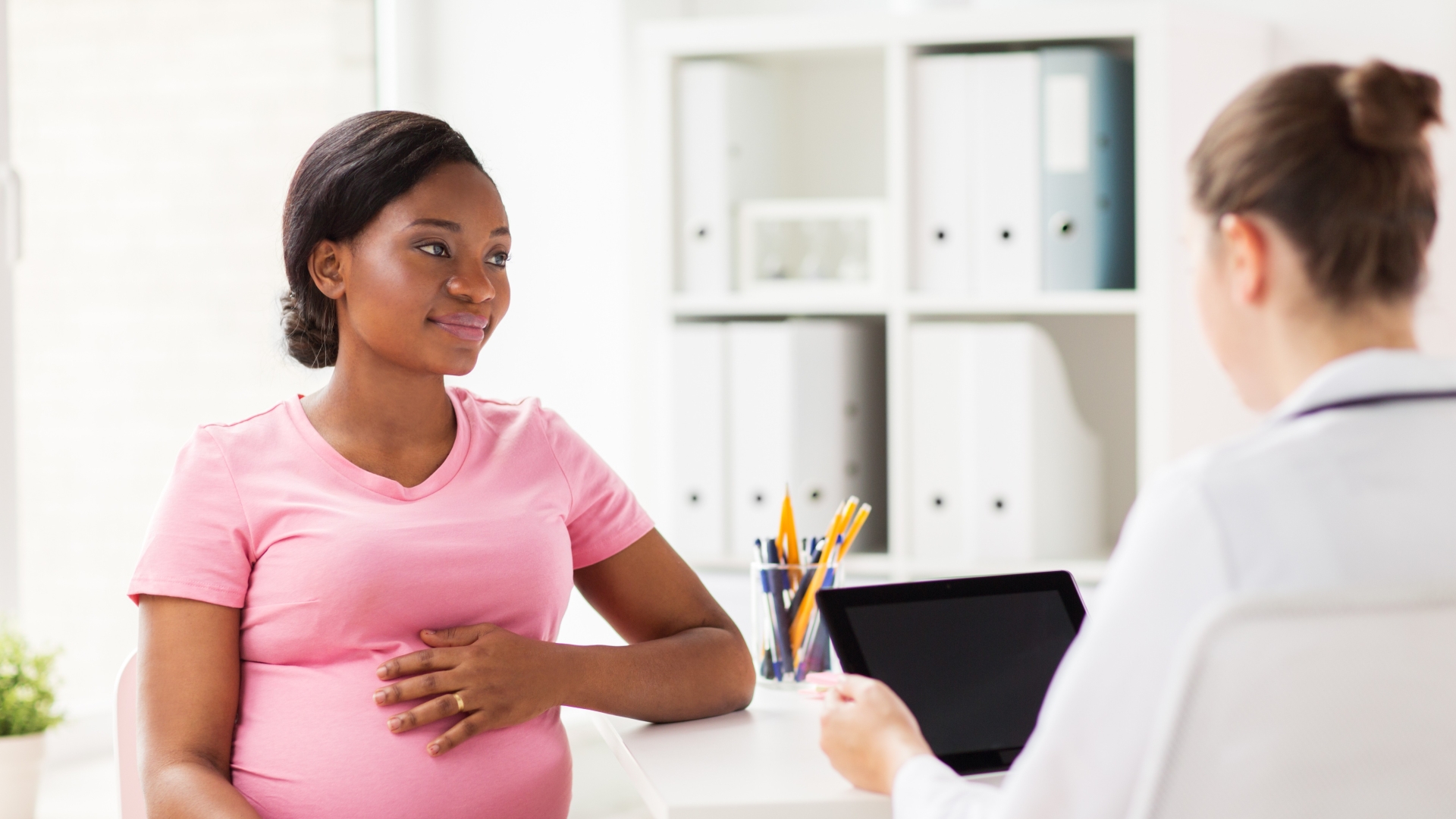Doctor and pregnant woman discussing early maternal risk detection.